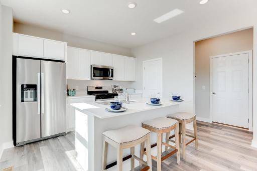 Enjoy having beautiful quartz counters with space for three to sit, and a great kitchen that includes stainless appliances and a huge walk in pantry. Model photos. Options and colors may vary.