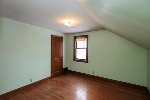 3rd bedroom on the upper level with hardwood floors and a walk-in closet.