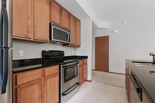 The kitchen features solid surface countertops and stainless steel appliances.