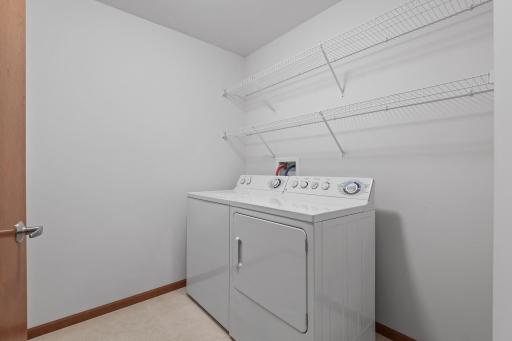 The large laundry room has wire shelving and plenty of space to make it your own!
