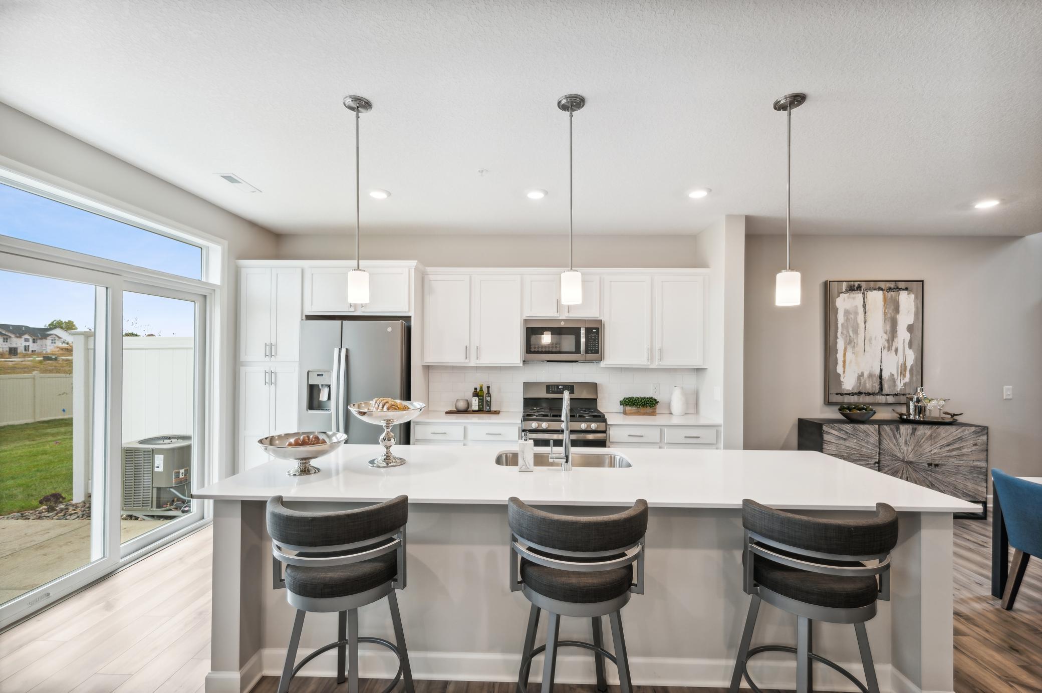 Welcome to the St. Clair! Offering a spacious kitchen with large island, quartz countertops, tile backsplash, white cabinets, pull out trash/recycling cabinet and popular slate finish appliances! *Photos of model home; colors and finishes will vary.