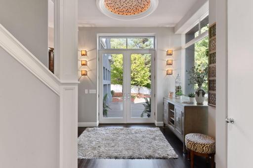 The bright and welcoming foyer was remodeled with designer light fixtures and a hand-laid tile dome featuring accent lighting.