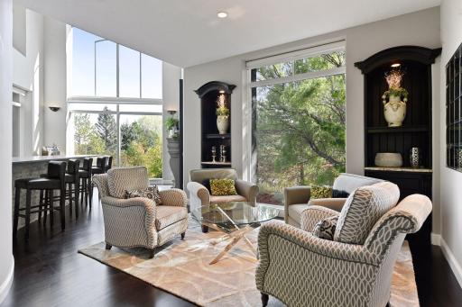 The sitting room features a floor-to-ceiling window flanked by two custom built-in bookcases with granite countertops.