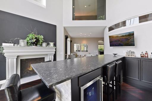 The custom bar offers seating for eight around a leathered granite countertop.