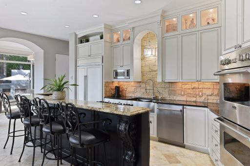 Photo for 1450 W Farm Road, Chaska, MN 55318 - Listing #6113107 Masterfully crafted with detailed corbels, the extensive custom cabinetry is outfitted with pull-out shelving, a recycling center, and seeded glass cabinet doors lit with accent lighting.
