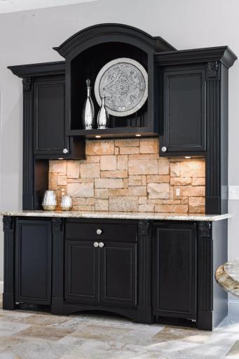 The built-in buffet features a stone backsplash and two beverage refrigerators.