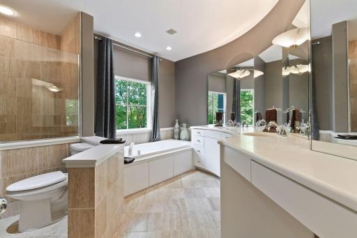 The master bathroom features a large soaking bathtub and separate shower with a glass enclosure.