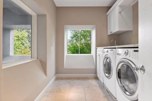 A second laundry room is conveniently located on the upper level and offers a granite topped folding counter, a linen closet and laundry sink.
