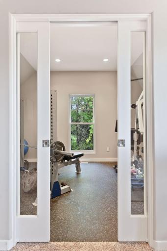 Sliding glass pocket doors open into the exercise room.