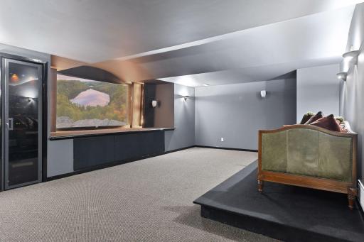 Movie night is an event in this home theatre. The spacious room is designed for stadium seating and features a surround sound system, large screen and closet for all your audio/visual equipment.