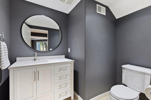 A half bathroom with a furniture-style vanity completes the lower level.
