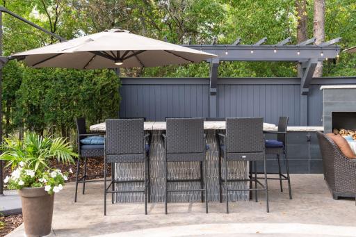 The outdoor entertaining space includes a high-top table and serving buffet with outlets so you can keep your snacks warm or charge your electronics!