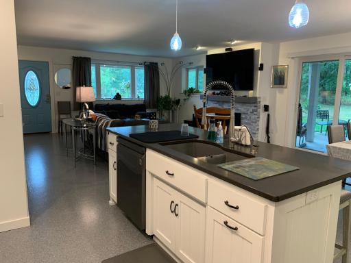 Kitchen island with QUARTZ countertop, dishwasher, and sink, offers an amazing view to the patio area, the outdoors and wildlife.