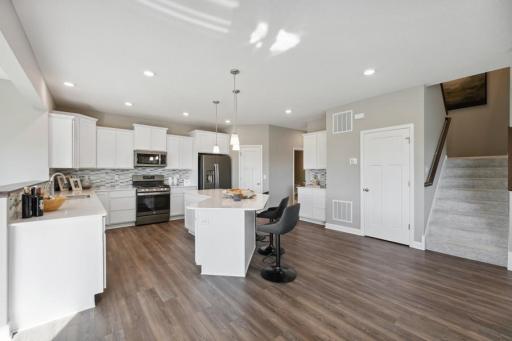 Open and naturally bright, the home's kitchen space if highly desirable and features a large center island serving as the perfect centerpiece for cooking and entertaining! (Photo of decorated model, actual home's finishes may vary slightly)