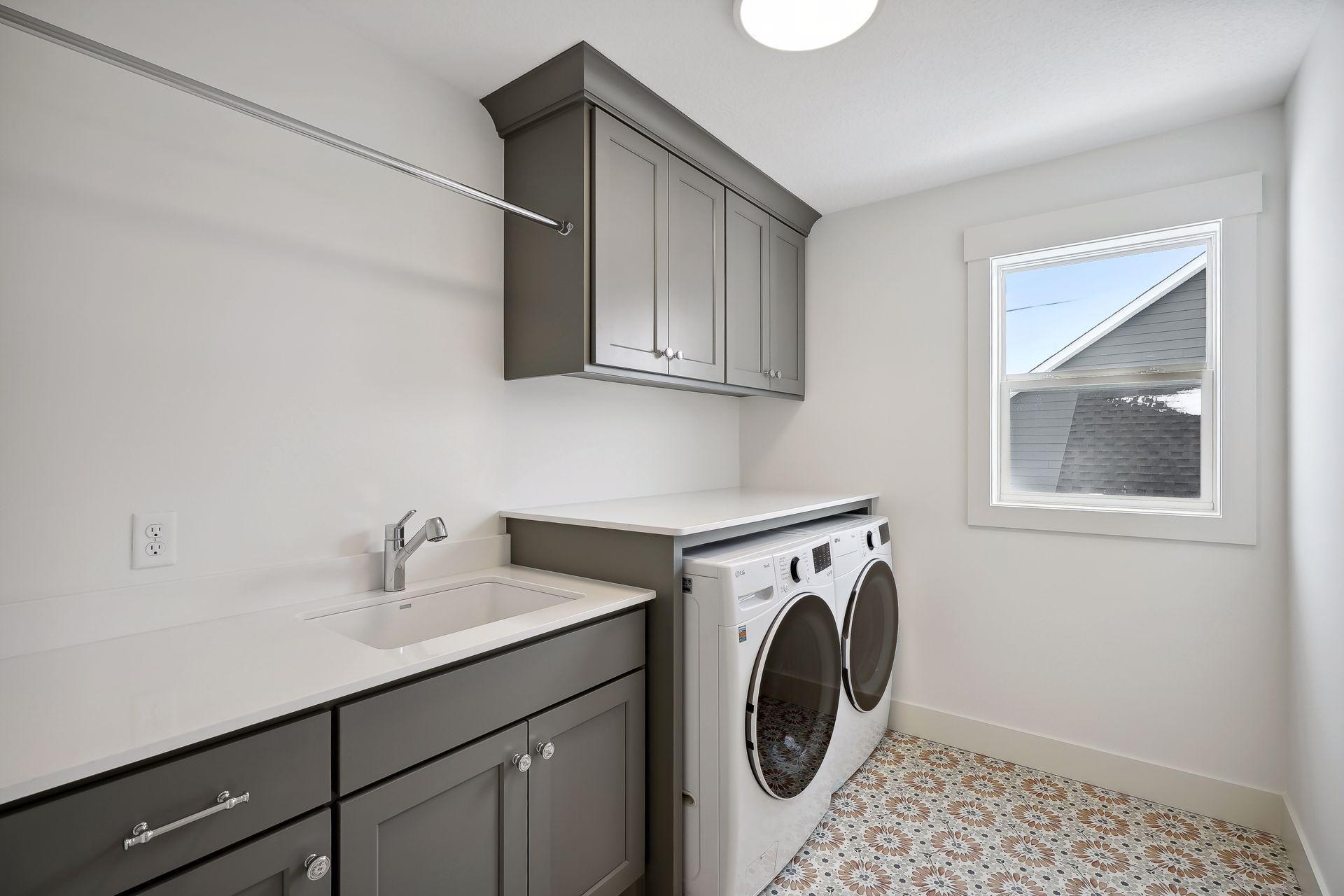 Second floor Laundry with extra cabinetry, countertop and tile flooring