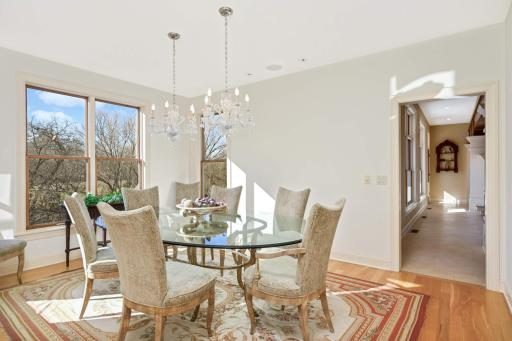 The formal dining area is illuminated by natural light by day and elegant chandeliers at night.