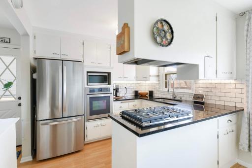 The kitchen features recent SS appliances, granite countertops & tile backsplash.