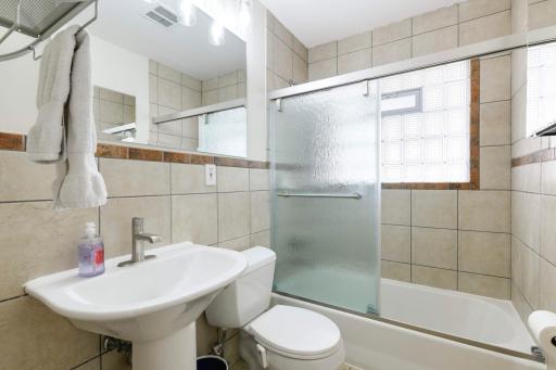 The main floor bath is full and features ceramic tile & glass block window.