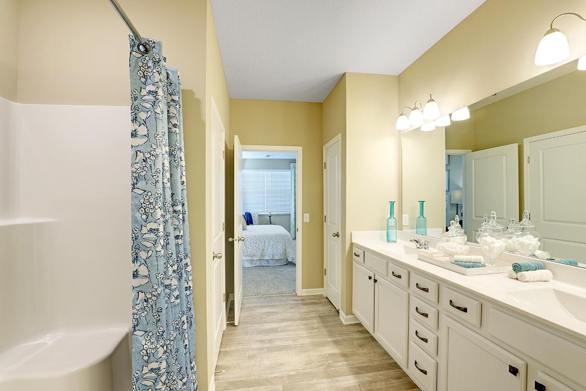 Huge primary suite bathroom with double vanity sinks.