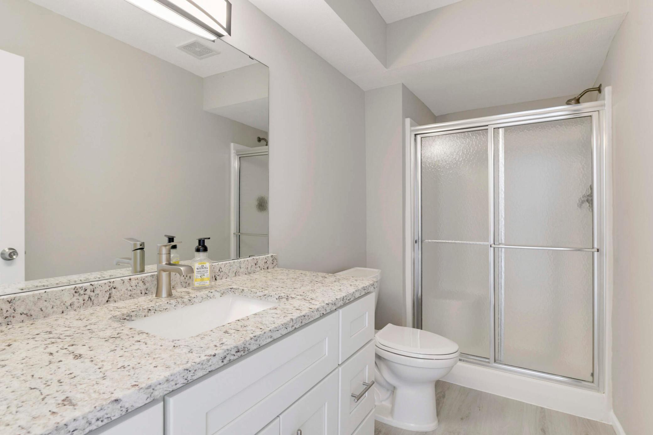 Beautiful white vanity and granite countertop in the main floor 3/4 bathroom