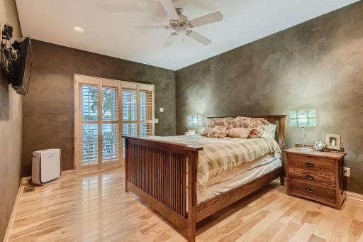 First floor owners suite. Gorgeous HDWD floors, a set of doors with plantation shutters that lead out to the stamped concrete patio, a huge bathroom and walk in closet