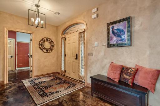 Coming in the front door you will find a warm welcoming front foyer area. One of the features in this home is the acid washed concrete flooring with in floor radiant heat throughout. Off to the right is your garage entry back door area.