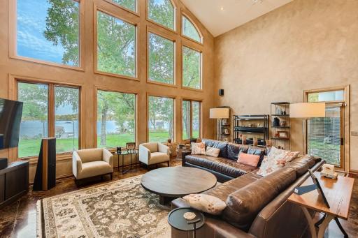 Check out this stunning main floor family room with 24 ft ceilings and a wall of windows facing the beautiful lake frontage.