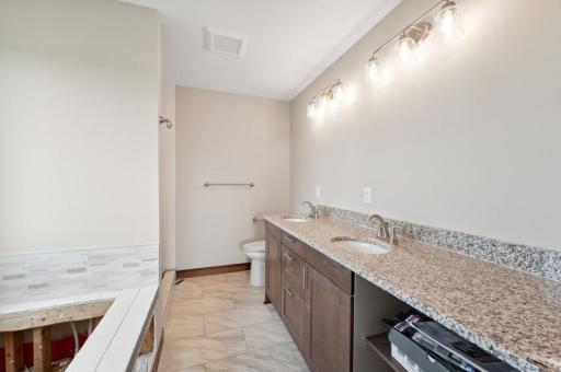 Owner's en suite bathroom offers double bowl vanity, separate tub and custom shower