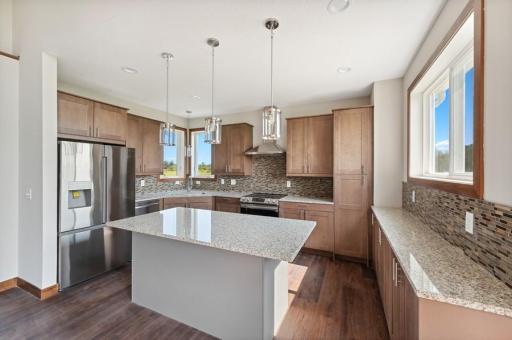 Spacious kitchen featuring stainless steel appliances, granite countertops, and kitchen windows overlooking the countryside