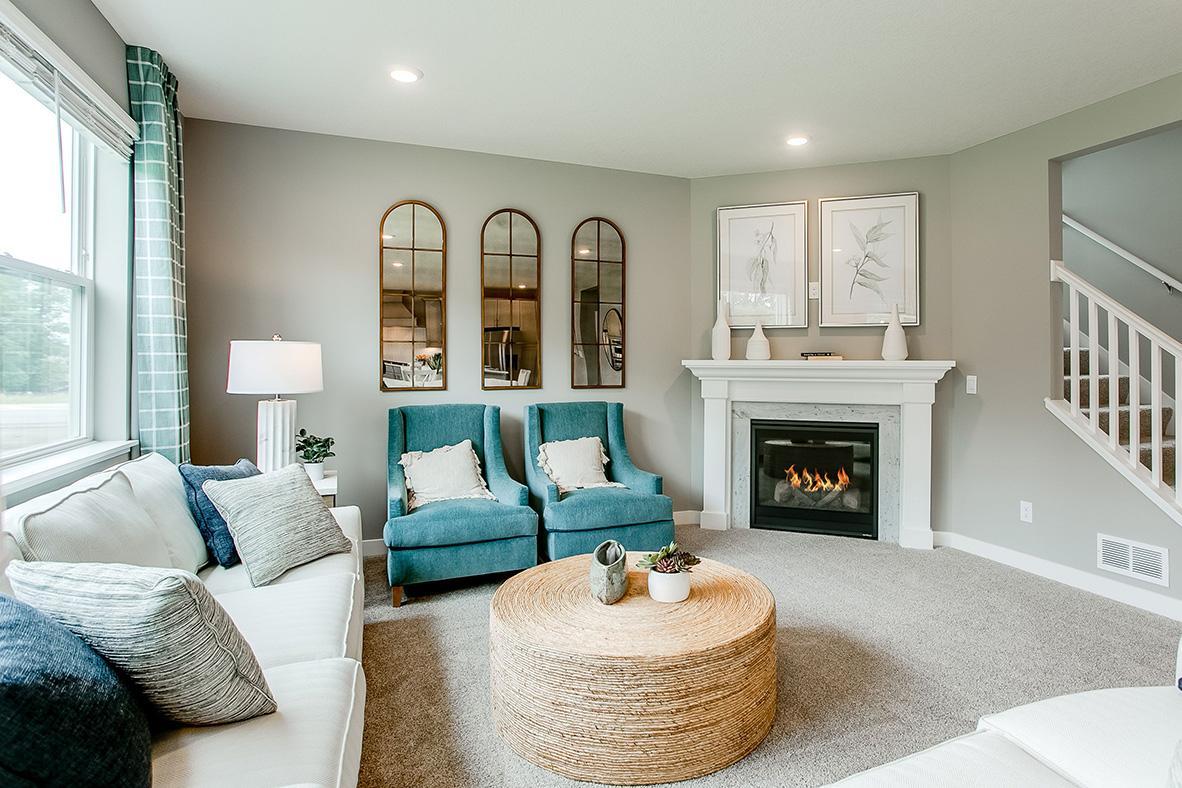 Soaring windows flood your main level family room in natural light - a space punctuated by a glowing corner gas fireplace. (Photo of model)