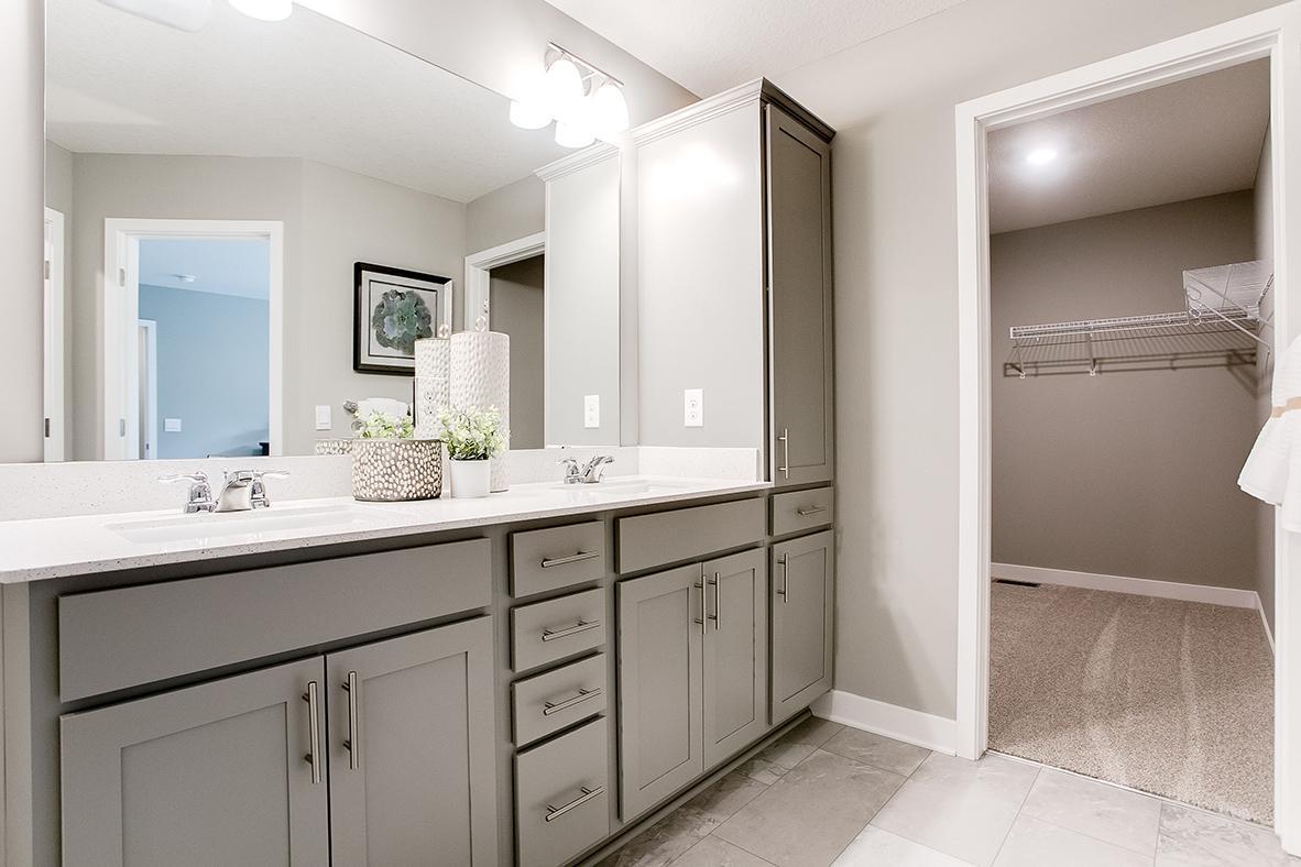 An extension of the primary suite, this private and spacious bathroom contains a double-vanity, an oversized stand-in shower, private stool room and access to the suite's second walk-in closet!! (Photo of model)