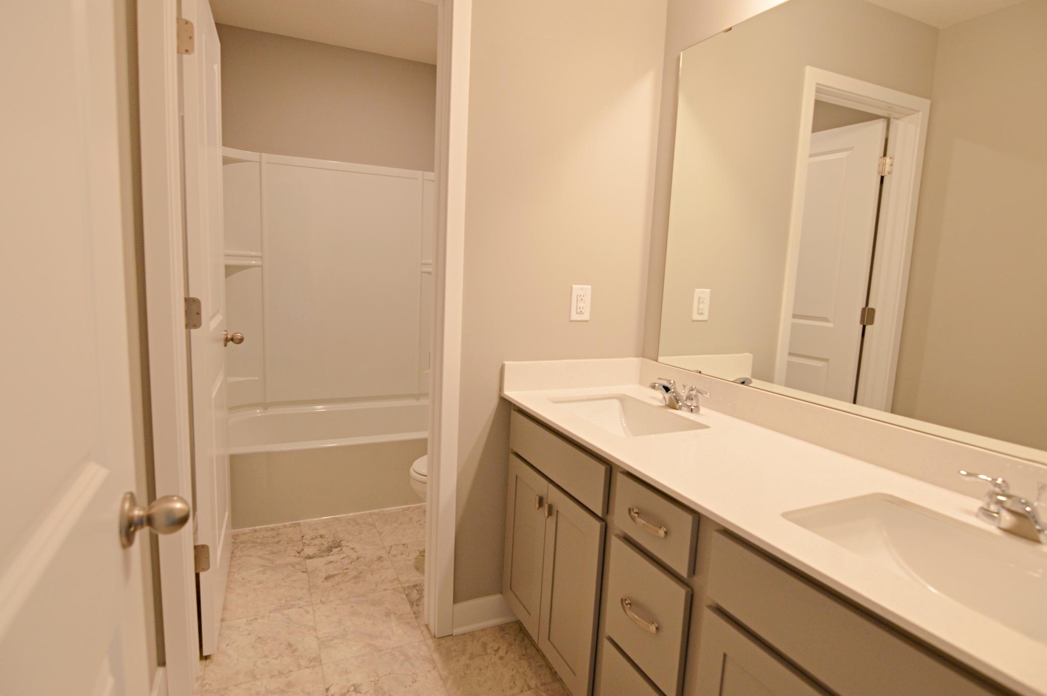 The home's actual secondary bathroom features a double vanity, and private stool/tub area!