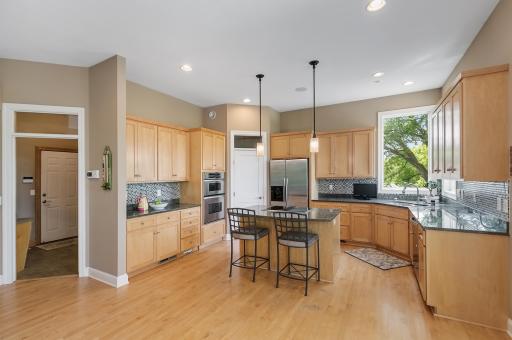 Kitchen with granite counter tops, stainless appliances, sandwich bar, walk in pantry