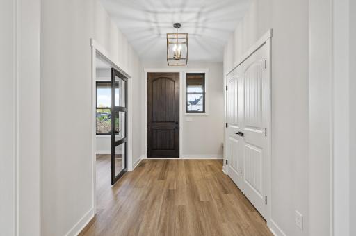 Font foyer with coat closet and small bench to the side