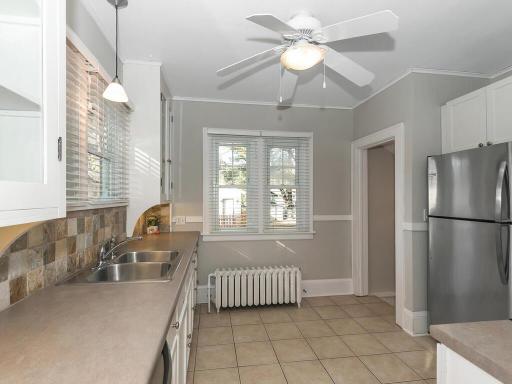 Ample sized kitchen in the rear of the home decorated in white millwork