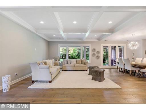 Great room with coffered ceiling inset with crown moulding and a beautiful wall of Marvin windows and patio door to let nature's light dance from space to space.