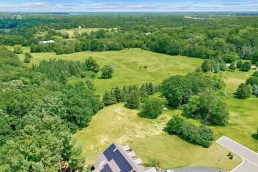 The light green grass just above the house is part of the open area.