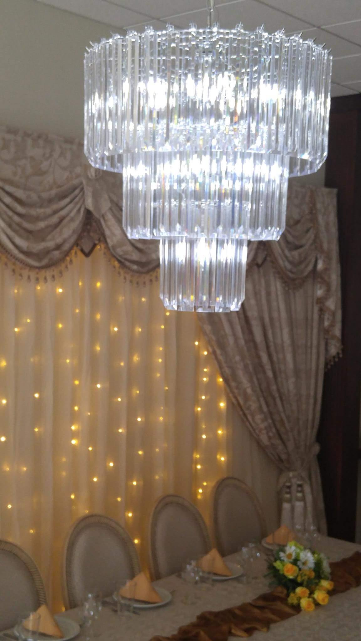 Exquisite chandeliers on either side of the backdrop for a grand feel during special events.