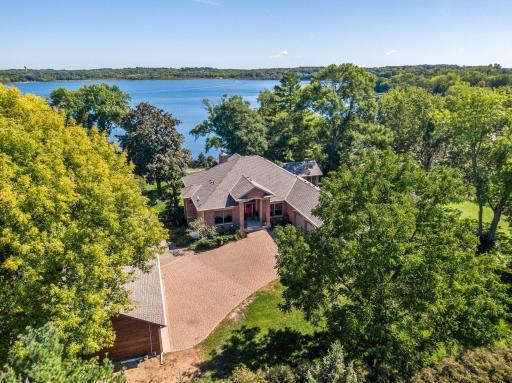 Surrounded by mature trees and nestled on a private lot, this custom built home is a stunning in-town retreat on the shores of Lake Minnewashta.