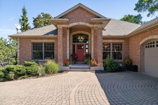 The beautiful paver driveway leads up the inviting front door.
