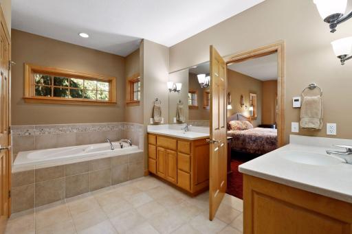 A private spa, the master bathroom features heated tile floors, separate comfort-height vanities and a large jetted bathtub.