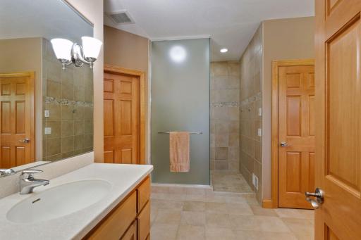 The spacious walk-in shower is fully tiled and offers a frosted glass enclosure. Two walk-in closets complete the master suite.