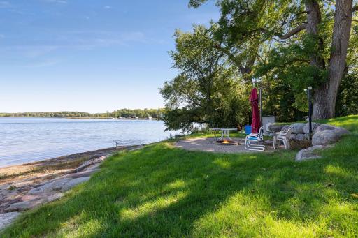 Professionally landscaped, the shoreline features a sandy beach and paver patio wit ha campfire ring.