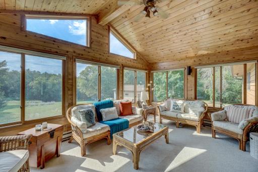 Large sunroom with vaulted ceilings & expansive views with access to the back deck