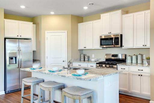 Beautiful and timeless white kitchen with large island. Model photos. Options and colors will vary.