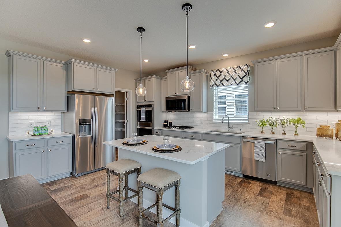 All of that beauty, yet function galore! Notice the space allowed throughout - plus an oversized pantry closet tucked back behind the refrigerator! A chef's dream!!! Photo of model home, color and options will vary.