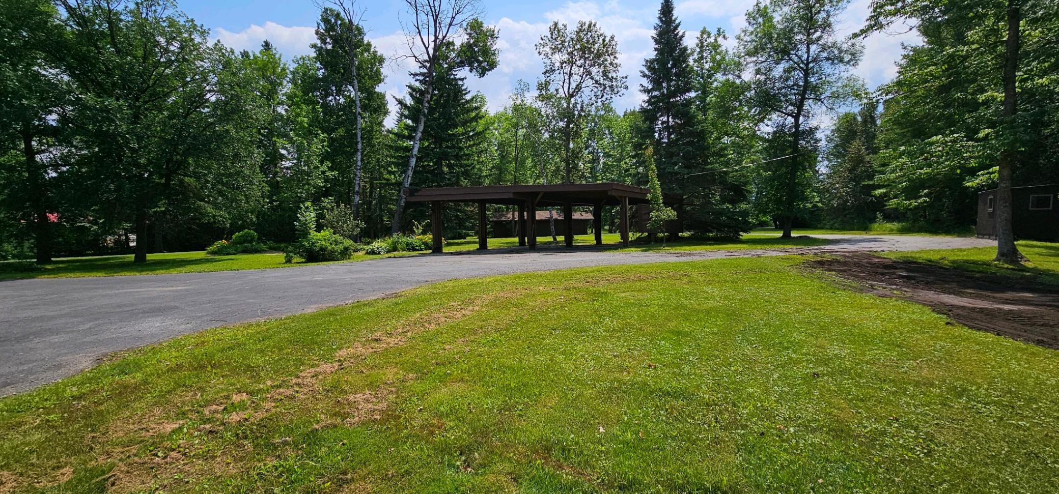 View looking out toward the highway. Carport for two cars, two sheds on each side of the property (not in pics) and to the far center, two additional smaller garages.