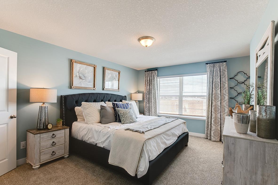The primary bedroom, with enough space to accommodate a king sized bed. Model home photo, colors and selections may vary.