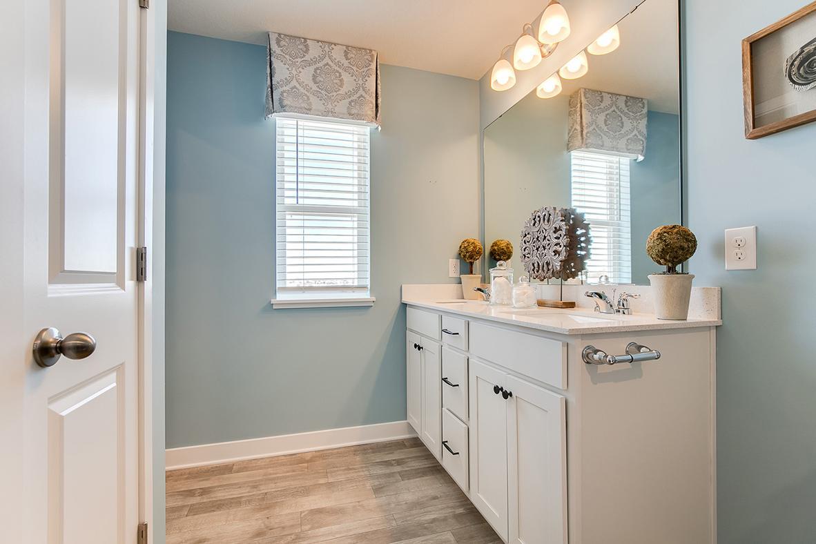 The bathroom located in the primary bedroom complete with quartz counter top vanity and dual sinks. Model home photo, colors and selections may vary.
