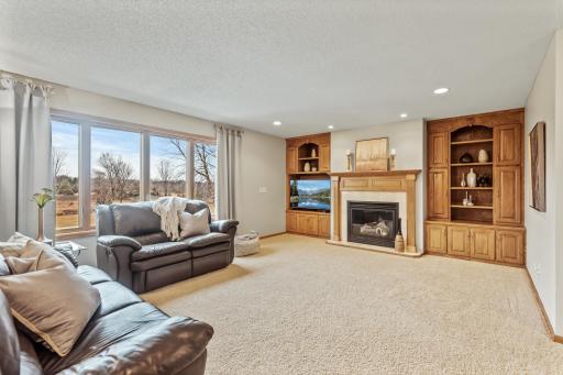 Quality built in custom cabinetry surround the cozy gas fireplace in this spacious family gathering space.